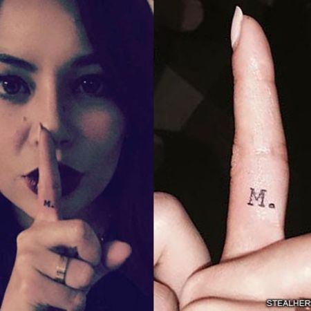 The M tattoo on Janel's finger